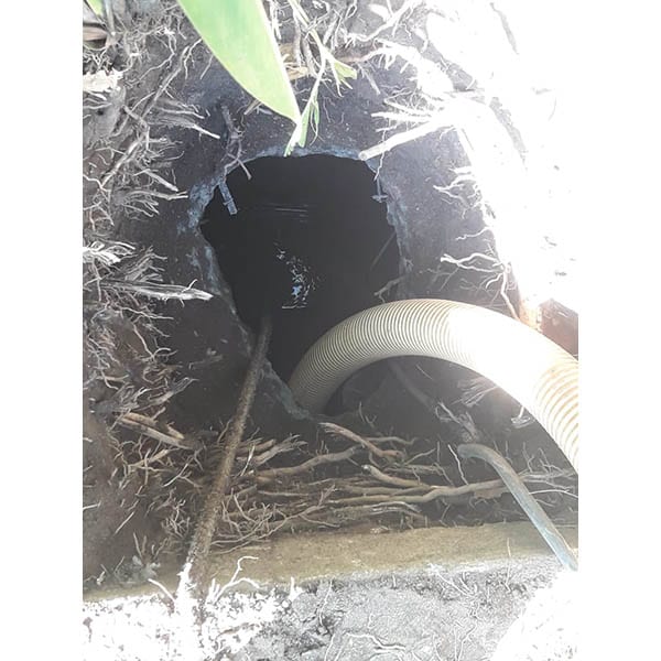 Corte de tubería subterránea para reparación de plomería, con equipo especializado en servicios técnicos de fontanería y mantenimiento de redes de agua y alcantarillado.